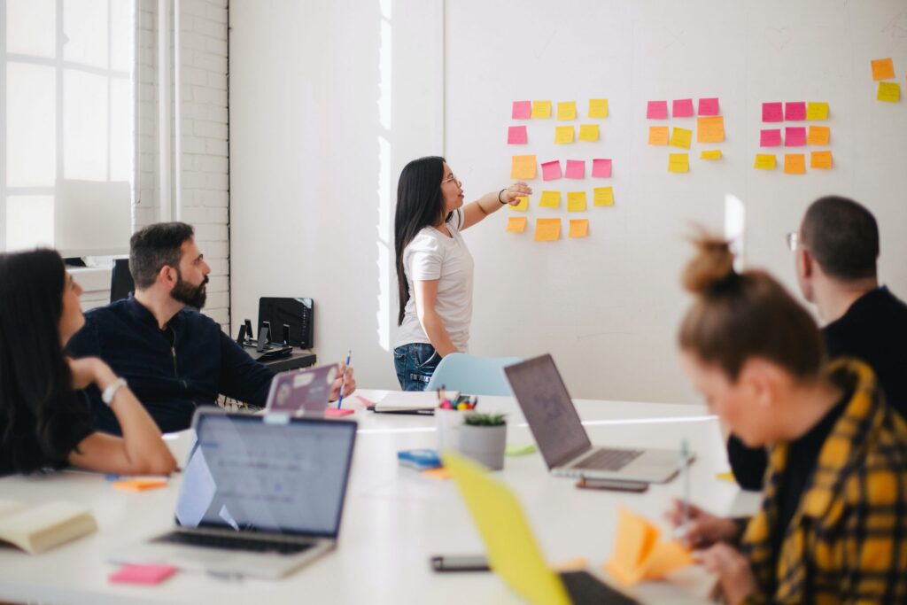 Project team planning a schedule with sticky notes on a whiteboard