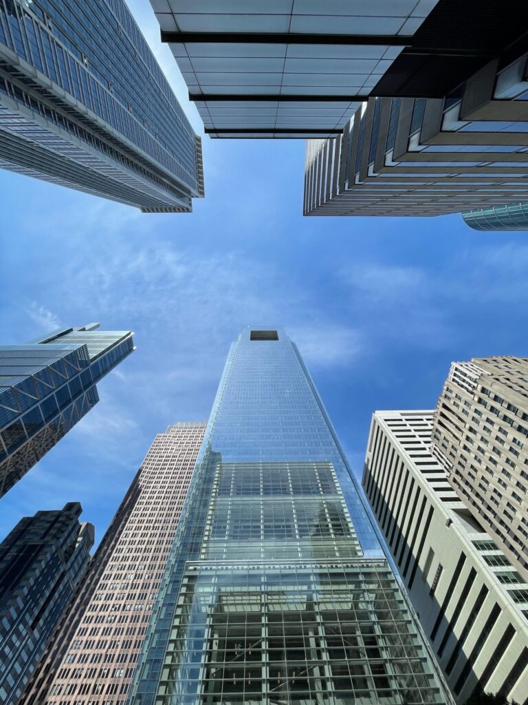 Looking up at modern high-rise towers against a blue sky